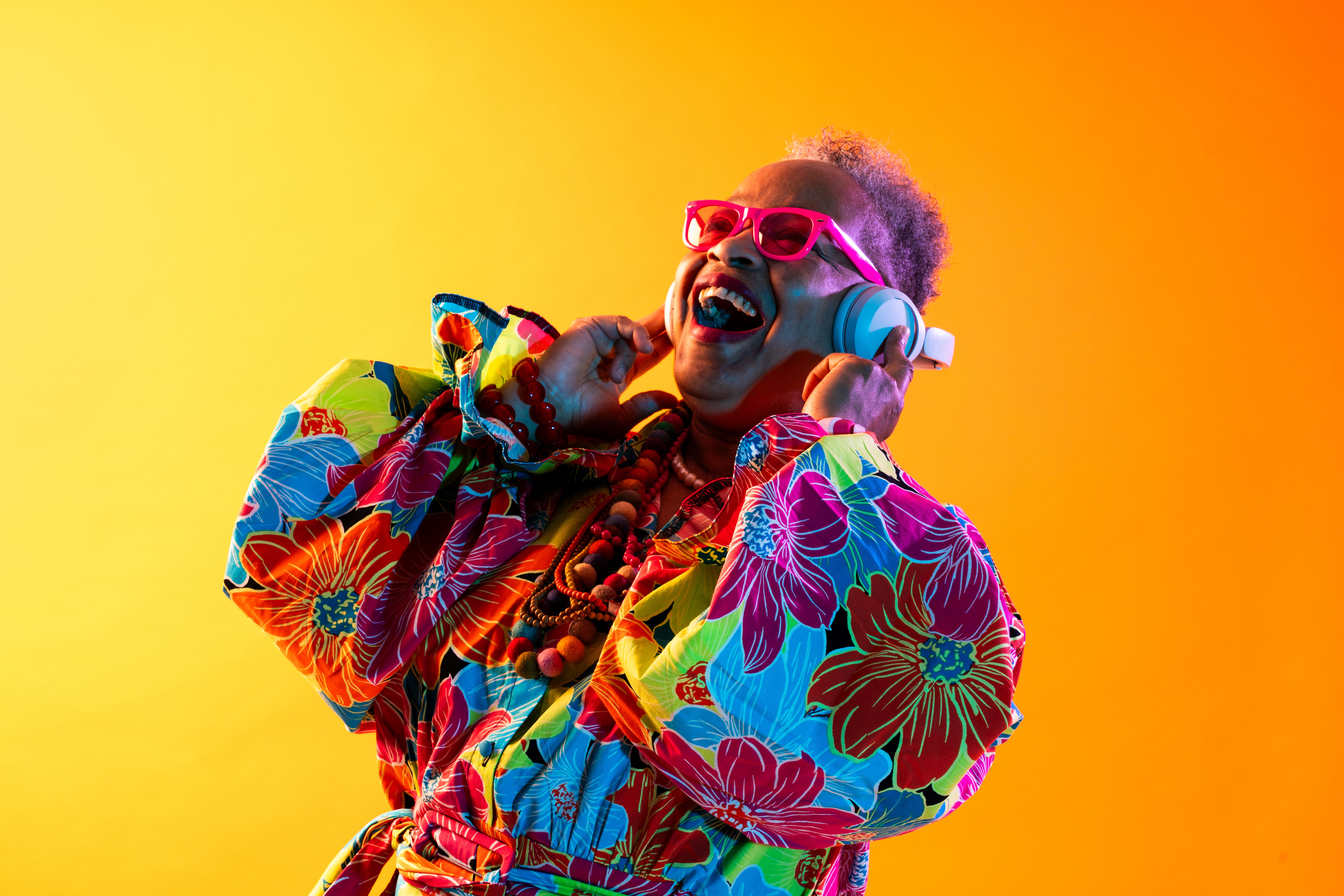 Senior citizen enjoying music with colorful headphones